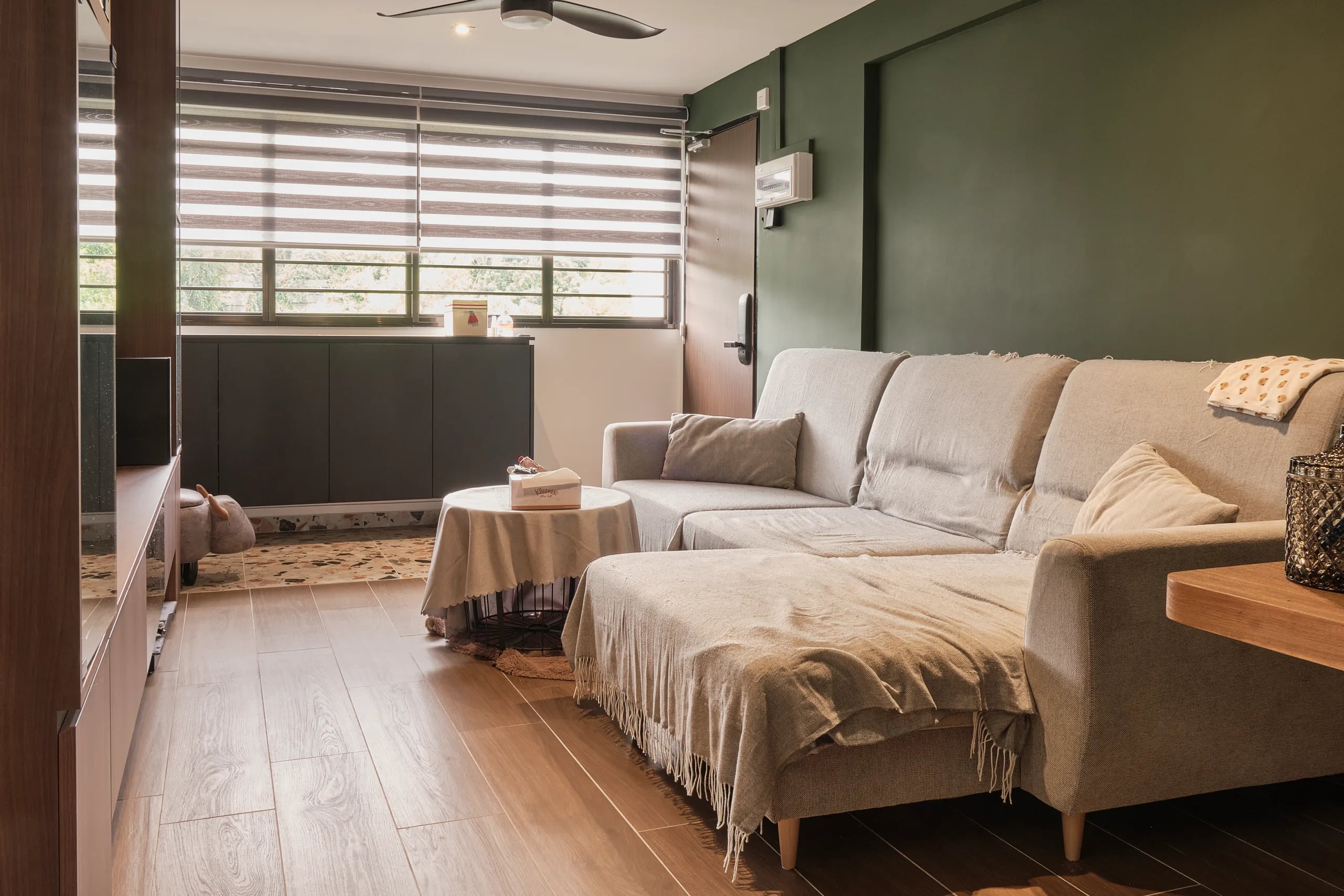 Off-white 3-seater sofa with sage green painted wall and blinds