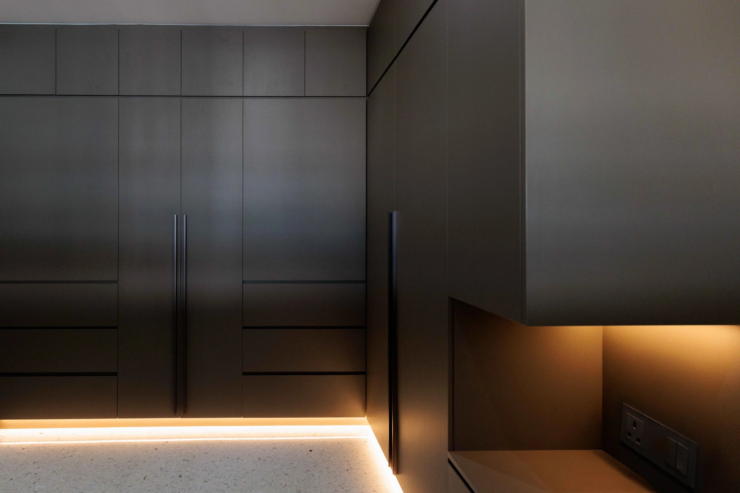 Full height cabinets in dark laminate L shape LED footer
