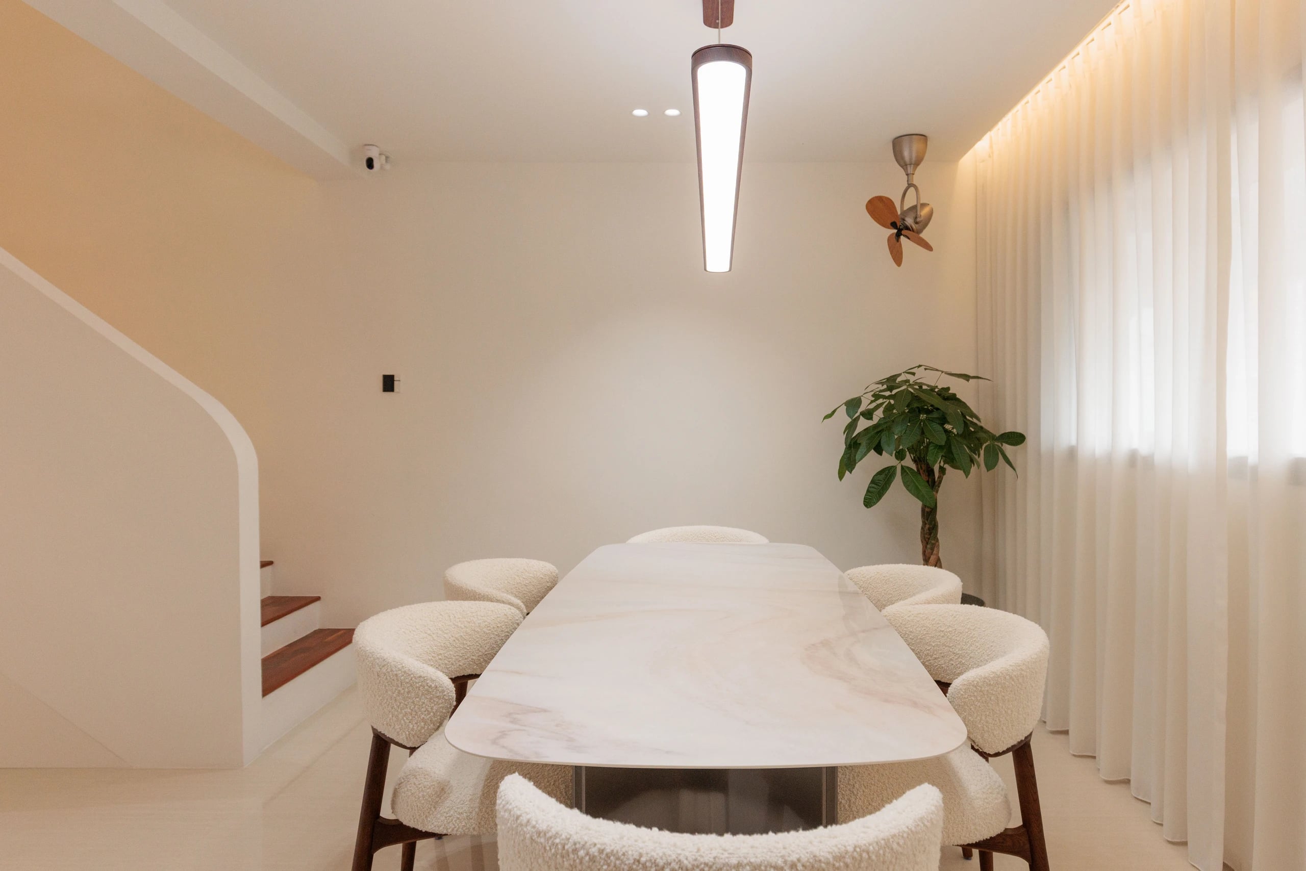 Dining table, chairs, and stairs in background